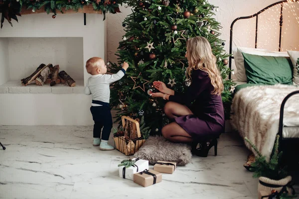 Mamá decora un árbol de Navidad con su amado hijo en casa —  Fotos de Stock