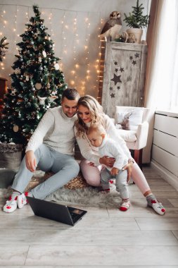 Heyecanlı anne, baba ve çocuk dizüstü bilgisayara bakıyor.