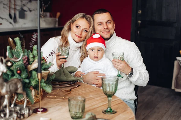 Gelukkig moeder met haar man en kind aan fancy kersttafel — Stockfoto