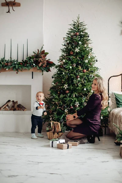 Hijo y madre en hermoso árbol de Navidad. —  Fotos de Stock