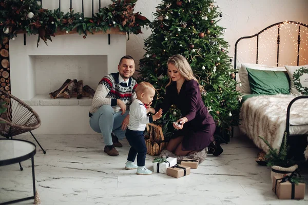 Hermosa mamá y papá decora un árbol de Navidad con su hijo amado en casa —  Fotos de Stock