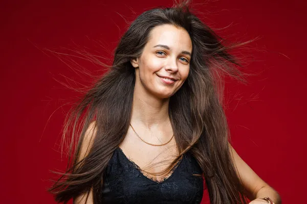 Plan de tête de brune souriante aux cheveux longs jeune femme joyeuse aux cheveux sains sur fond rouge avec espace de copie — Photo