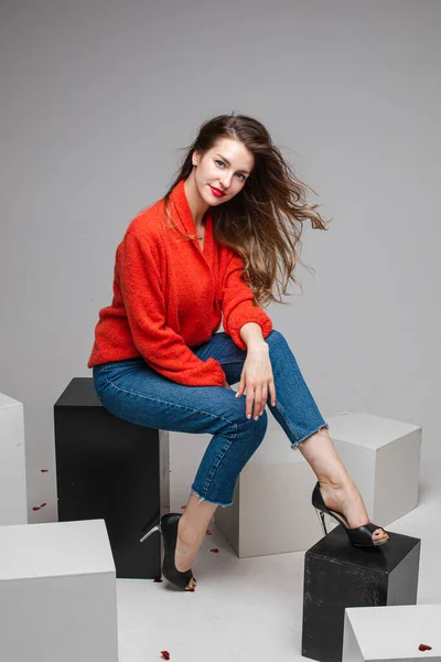 Sorrindo bela mulher em camisola vermelha posando em estúdio — Fotografia de Stock