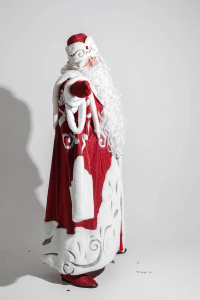 Headshot de Papai Noel em chapéu vermelho, homem cansado de cabelos grisalhos no fundo do estúdio cinza — Fotografia de Stock