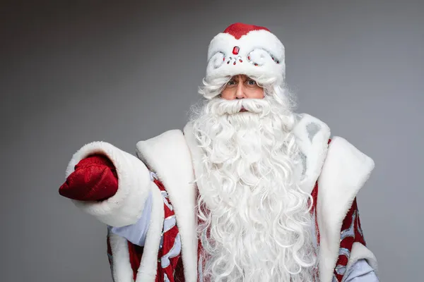 Headshot de Papai Noel em chapéu vermelho, homem cansado de cabelos grisalhos no fundo do estúdio cinza — Fotografia de Stock