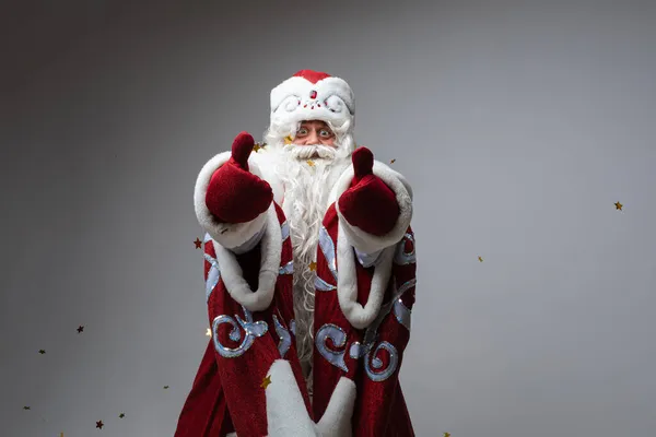 Снимок Санта-Клауса в красной шляпе, седой бородатый уставший мужчина на фоне серой студии — стоковое фото