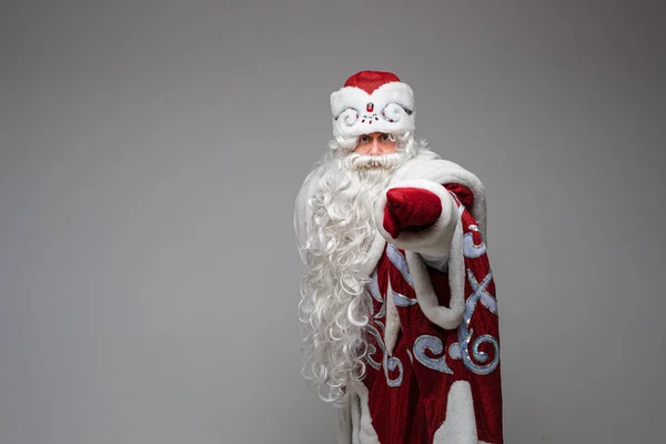 Santa Claus wskazując ręcznie na puste miejsce na szarym tle studio z miejsca na ksero na Boże Narodzenie reklama nowego roku — Zdjęcie stockowe