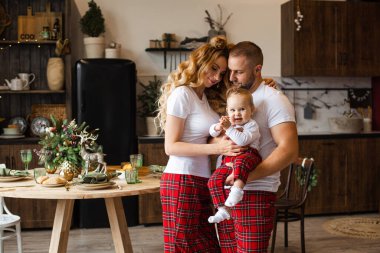 Gülümseyen küçük ebeveynler ve pijama giyen küçük çocuklar.