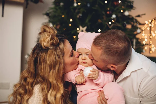 크리스마스 아침 크리스마스 트리 근처에 어린 딸 과 함께 있는 어린 가족들 — 스톡 사진