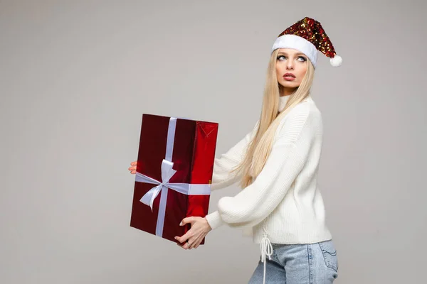 Hermosa mujer en Santa sombrero posando con caja de regalo — Foto de Stock