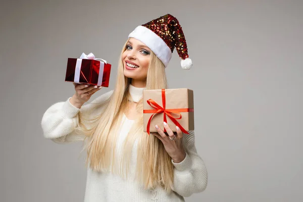 Sonriente hermosa mujer mostrando regalos de Navidad en el estudio — Foto de Stock