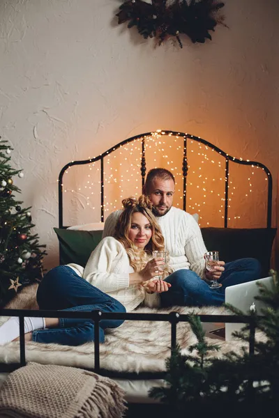 Schönes Paar mit Getränken auf dem Bett. — Stockfoto