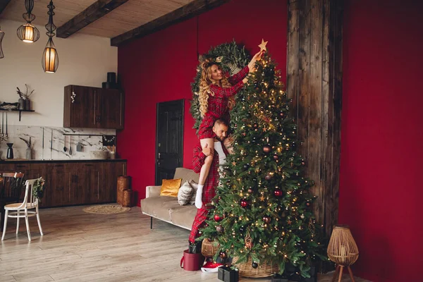 Caucasian loving couple decorating Christmas tree together — Stock Photo, Image