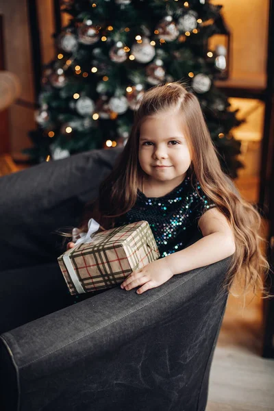 Schattig klein meisje met kerstcadeau glimlachend op camera. — Stockfoto