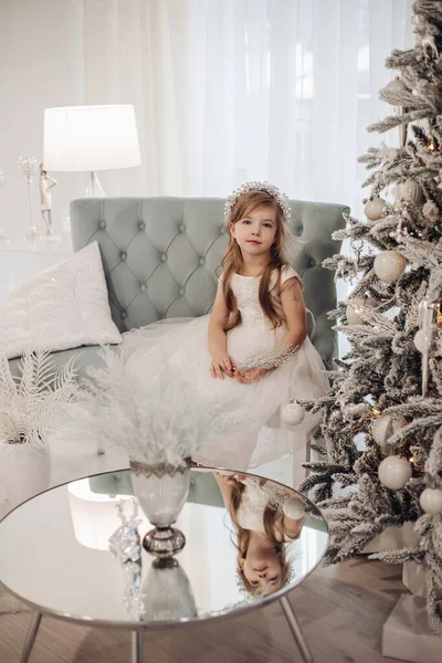 Прекрасна дівчина в білій сукні з різдвяною гілкою в руках . — стокове фото