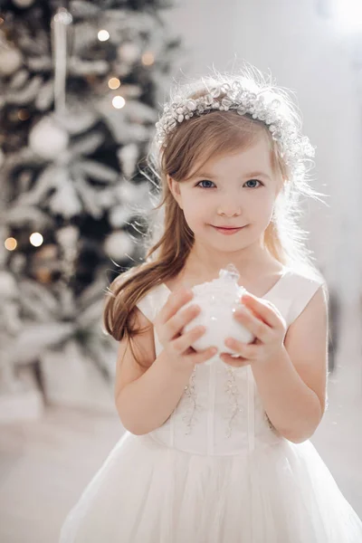 漂亮小孩的画像，拿着一个白色的圣诞玩具，微笑着 — 图库照片
