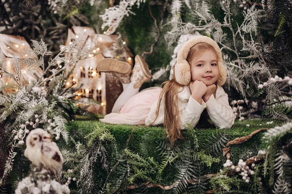 Фотографія привабливої маленької дівчинки в легкому одязі лежить на різдвяній прикрасі з деревами — стокове фото