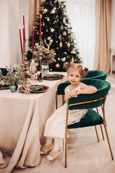 Красива дівчина в красивій сукні сидить і чекає різдвяної вечері — стокове фото
