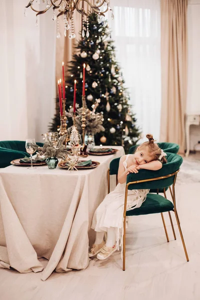 Красива дівчина в красивій сукні сидить і чекає різдвяної вечері — стокове фото