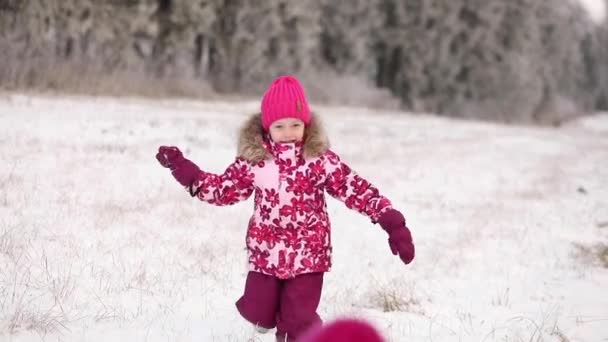 Ibu muda dan putri kecil di salju. ruang cipta. Keluarga bersenang-senang di musim dingin yang cerah di luar ruangan — Stok Video