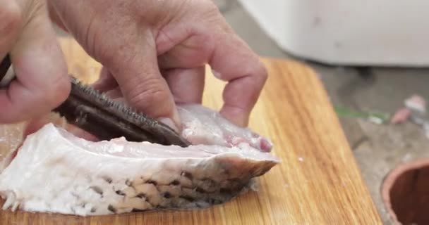 Tagliare il pesce fresco con un coltello. Le mani di uomini tagliano il pesce per pranzo — Video Stock