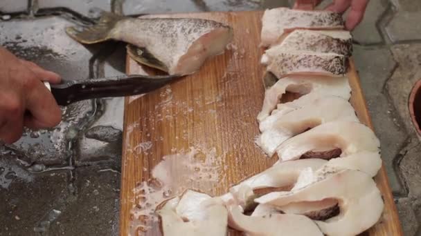Tagliare il pesce fresco con un coltello. Le mani di uomini tagliano il pesce per pranzo — Video Stock