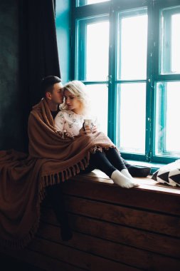 Oturan ve pencere kenarındaki pencerenin yanında yarışan çift.