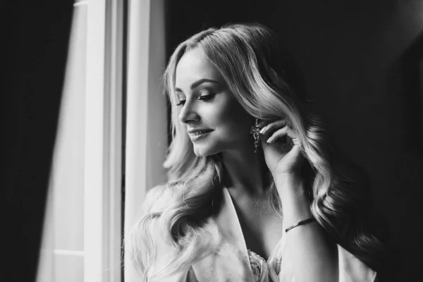 Gorgeous bride standing near balcony and looking in big window. — Stock Photo, Image