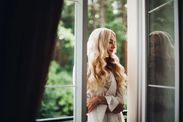 Nádherná blonďáku nevěsta chodící na balkón a čekající na ženicha. — Stock fotografie