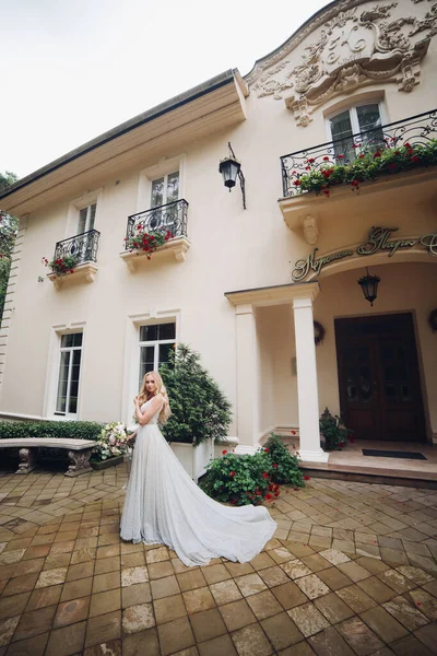 結婚式のボケと豪華な家に対してポーズ完璧なウェディングドレスの花嫁. — ストック写真