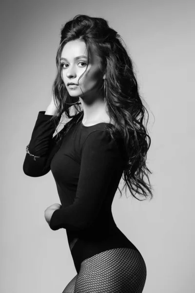 Jolie fille avec une silhouette sexy, les cheveux longs brun glancy posant au studio . — Photo