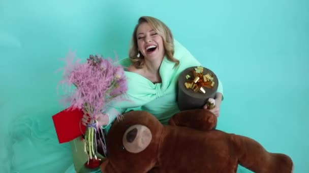 Krásná žena s dary ve studiu. Příjemná pozitivní žena se směje a užívá si dovolenou s dárky — Stock video
