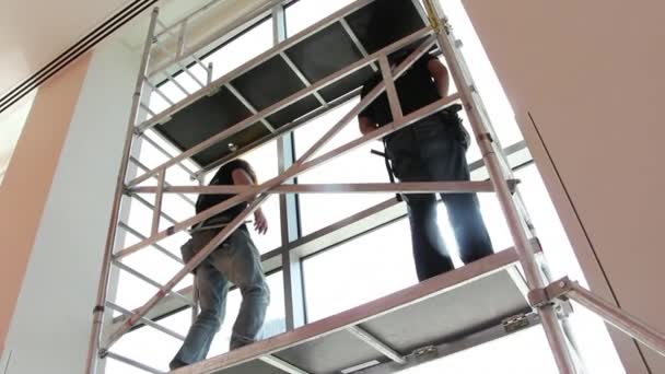 Handyman on ladder scrap window — Stock Video