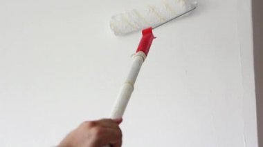 Whitewashing a wall with roller paintbrush