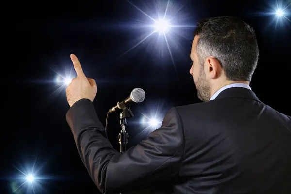 Rear view of a speaker speaking at the microphone Stock Picture