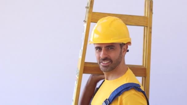 Constructor con paños de trabajador de pie en una escalera — Vídeos de Stock