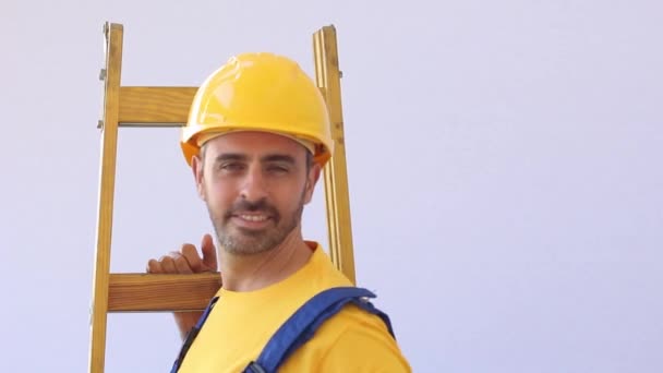 Builder with worker cloths stand on a ladder — Stock Video