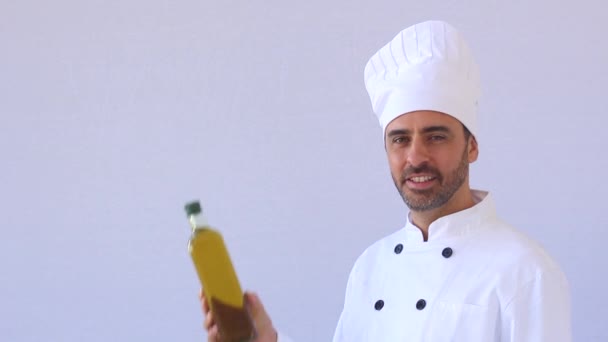 Бородатий шеф-кухар середнього віку в білому кольорі і форма стоїть, дивлячись на камеру з копійкою на білому — стокове відео