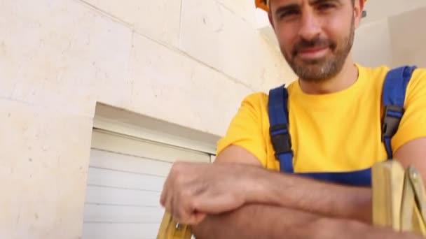 Constructor con paños de trabajador de pie en una escalera — Vídeo de stock