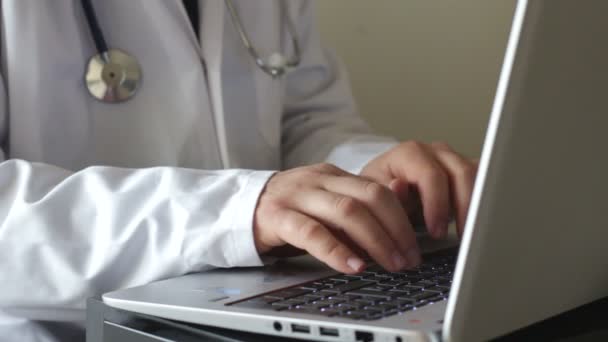 Médico escribiendo en el ordenador portátil — Vídeo de stock