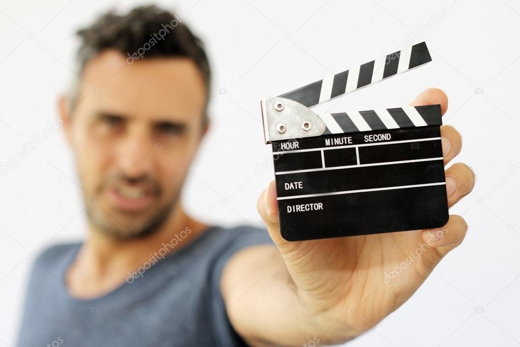 Young man holding movie clapper