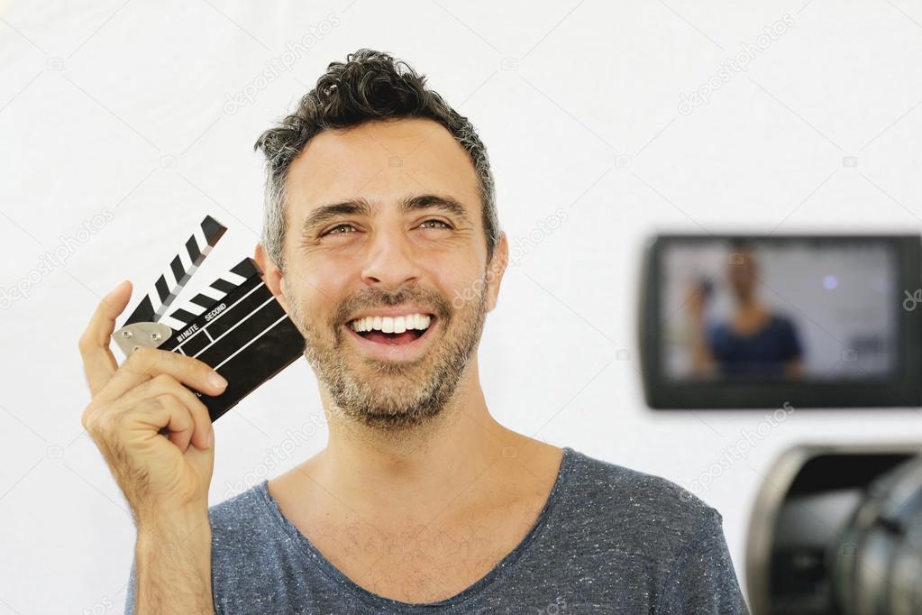 Young guy holding film clapper