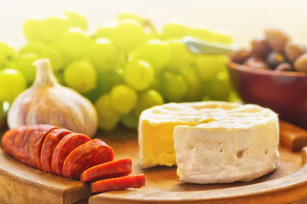 Queso Brie con aceitunas, uvas y chorizo —  Fotos de Stock