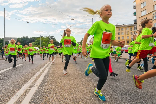 STOCKHOLM - AGO, 17: Primer plano de uno de los muchos grupos para niños en el evento Midnight Run for children (Lilla Midnattsloppet), un grupo de niños emocionados corriendo. Aug 17, 2013 in Estocolmo, Suecia — Foto de Stock