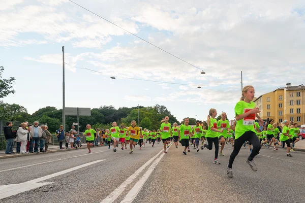 STOCCOLMA - 17 AGOSTO: Subito dopo l'inizio in uno dei tanti gruppi per bambini della Midnight Run per bambini (Lilla Midnattsloppet), un gruppo di bambini entusiasti che corrono — Foto Stock