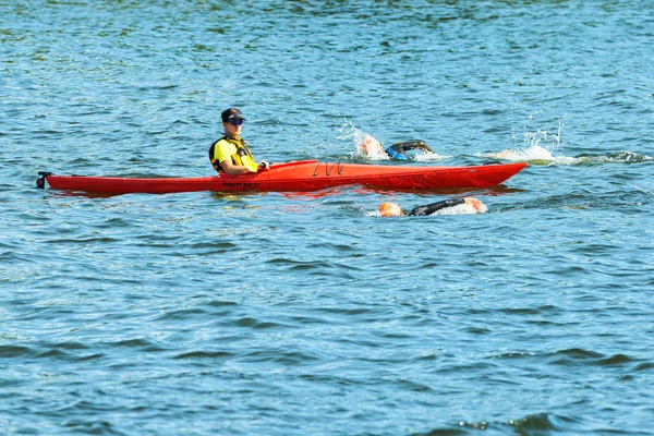 STOCKHOLM - AGO, 24: Dos triatletas que pasan por una canoa de seguridad roja durante el calentamiento, evento de la Serie Mundial de Triatlón UIT Femenina 24 ago 2013 en Estocolmo, Suecia —  Fotos de Stock