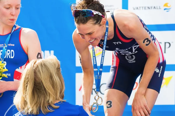 Stockholm - aug, 24: gouden medaillewinnaar gwen jorgensen nemen de medaille van gunilla lindberg (iok) op de womens itu world triathlon serie event 24 aug 2013 in stockholm, Zweden — Stockfoto