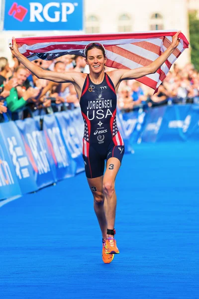 STOCKHOLM - AUG, 24: The winner Gwen Jorgensen running to the finish line with the USA flag in the Womens ITU World Triathlon Series event Aug 24, 2013 in Stockholm, Sweden — Stock Photo, Image