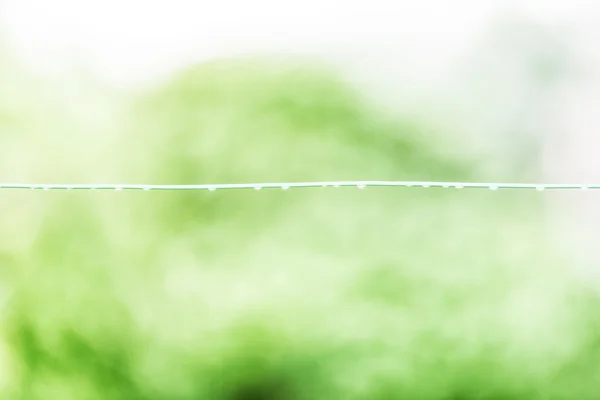 Yeşil arka plana sahip ıslak kablo — Stok fotoğraf