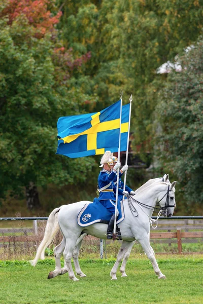 STOCKHOLM - SEP, 22 : Deux cavaliers de la garde montée entrent dans l'arène avec des drapeaux suédois lors de l "événement de la Garde montée pour le public à Ryttarstadion 22 sept. 2013 à Stockholm, Suède — Photo